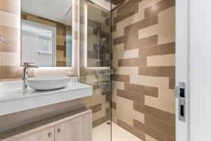 ein Badezimmer mit Waschbecken und Dusche in der Unterkunft Seven Palm Hotel with West beach access in Dubai