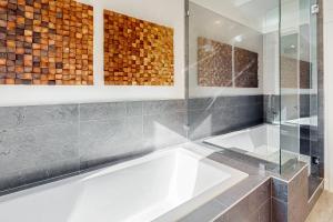 un baño con bañera y ducha de cristal en Sandlewood Sanctuary, en Park City