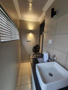 a bathroom with a white sink and a counter at 9 Levubu Cottages in Polokwane +38 photos