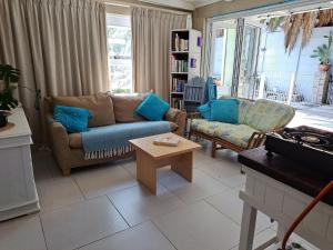 a living room with two couches and a coffee table at The Willow Cottage in Cape Town