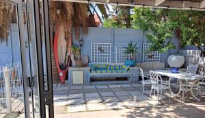 un patio avec un canapé, une table et des chaises dans l'établissement The Willow Cottage, au Cap