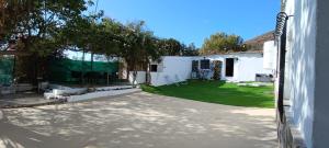 a backyard with a green lawn and a white building at La Jordana 39, Calblanque in Las Barracas
