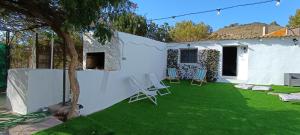 a yard with chairs and a white wall at La Jordana 39, Calblanque in Las Barracas
