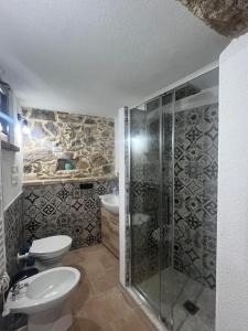 a bathroom with a shower and a toilet and a sink at Orani Guest House in Orani