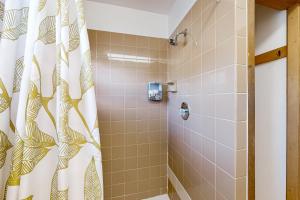 a bathroom with a shower with a shower curtain at The Manatee Cove - Side B: Studio in Cocoa +15 photos