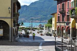 a man riding a bike down a city street at Confylake Home in Pisogne