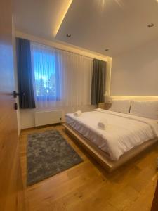 a bedroom with a large bed and a window at Apartman Mraz - Aparthotel Zlatni Javor in Jahorina