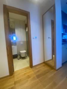 a bathroom with two mirrors and a toilet in a room at Apartman Mraz - Aparthotel Zlatni Javor in Jahorina