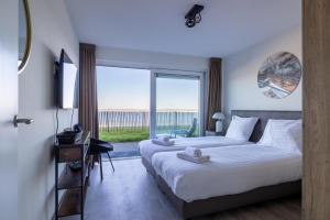 a hotel room with two beds and a large window at Vakantiewoning aan het strand - met tuin en terras - Vista Maris - Nr 34 in Sint Annaland