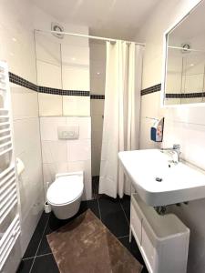 a white bathroom with a toilet and a sink at Hanse-Vermietung in Bremen +32 photos