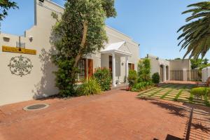 una casa con un vialetto di mattoni accanto a un edificio di Meerendal Cottage-Affordable Luxury-Private Garden with Pool & Hot Tub a Città del Capo