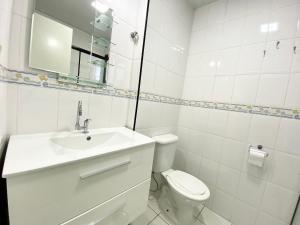 Un baño blanco con lavabo e inodoro. en Edifício Saint Domingos, en Samaritá