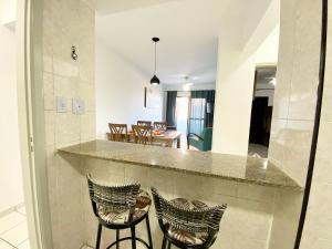 cocina con 2 taburetes y comedor en Edifício Saint Domingos, en Samaritá