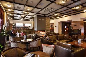 un restaurante con mesas y sillas de cuero y un bar en Snezhanka Apartments TMF, en Pamporovo