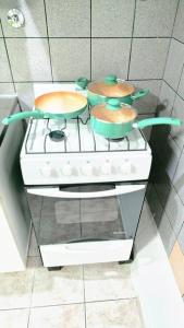 a stove with two pots on top of it at Departamentos aćawaia in Ushuaia