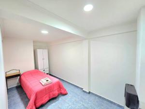 a bedroom with a bed with a red blanket at Departamentos aćawaia in Ushuaia