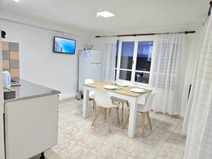 a kitchen with a table and chairs in a room at Departamentos aćawaia in Ushuaia +12 photos