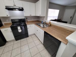 a kitchen with white cabinets and a black stove at Afforable Shared Housing in Houston