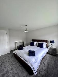 a bedroom with a large bed with blue pillows at Stunning flat in Webheath, Redditch in Redditch