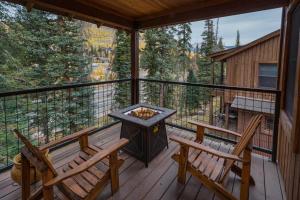 eine abgeschirmte Veranda mit zwei Stühlen und einer Feuerstelle in der Unterkunft Black Bear 86 in Durango Mountain Resort