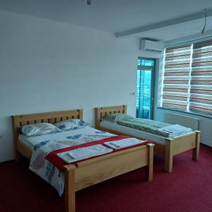 a bedroom with two beds and a window at Hollywood Motel in Podlugovi