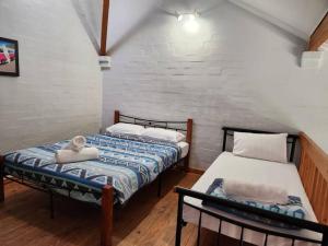 two twin beds in a room with a brick wall at Loft Villa Pool Spa & Beach Sleeps Six! in Mandurah