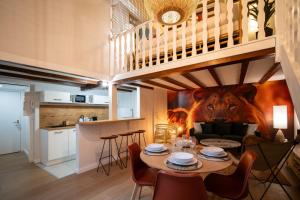 un comedor con una mesa y un mural de leones en Le Savane - Grand Triplex Confort & Chaleureux, 2 Salons, en Castres