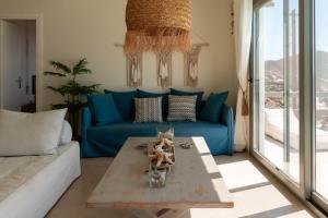 a living room with a blue couch and a table at Deja Blue Villa 1 in Agios Georgios