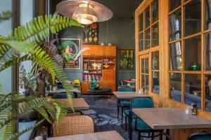a restaurant with tables and chairs and a plant at Boutiquehotel Staats in Haarlem