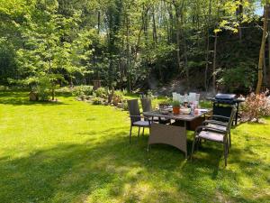 a table and chairs in the grass in a yard at Petit Château in Eupen