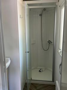 a shower with a glass door in a bathroom at mobilhome 4 étoiles in Gastes