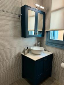 a bathroom with a sink and a mirror at Kyveli LuxuryRooms in Myrina +29 photos