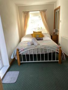a bedroom with a bed with a window at Rose Cottage room bee happy in Newquay