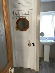 a bathroom with a white door and a sink at Rose Cottage Bee Happy anex in Newquay