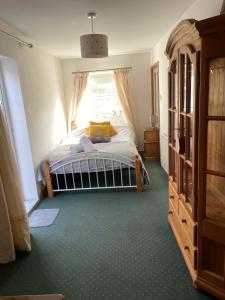 a bedroom with a bed and a window at Rose Cottage Bee Happy anex in Newquay