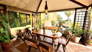 a patio with a wooden table and chairs and plants at Villa Lujo y Relax in Adeje by Deihu Experiences in Adeje