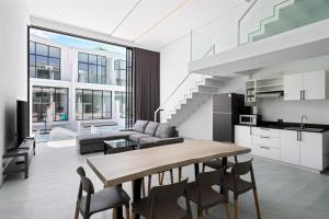a kitchen and living room with a table and chairs at Beach Walk Condo 3br in Replay in Bang Rak Beach