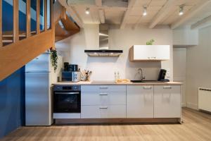 una cucina con mobili bianchi e una scala di Le Petit Verger, cosy 5 people a Vivonne