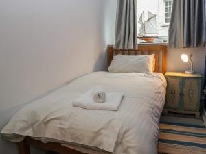 Un dormitorio con una cama con una toalla encima. en 10 Bay View Court, en Lyme Regis