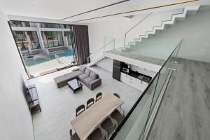a living room with a staircase and a couch and a table at Beach Walk Condo 3br in Replay residence in Bang Rak Beach