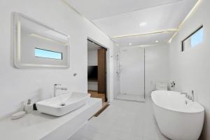 a white bathroom with a sink and a toilet at Beach Walk Condo 3br in Replay residence in Bang Rak Beach +8 photos