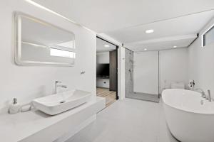 a white bathroom with a sink and a mirror at Beach Walk Condo 3br in Replay residence in Bang Rak Beach +8 photos