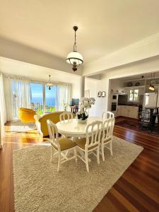 Una sala de estar con una mesa y sillas blancas. en A Velha Casa Caboz, en Ponta do Sol