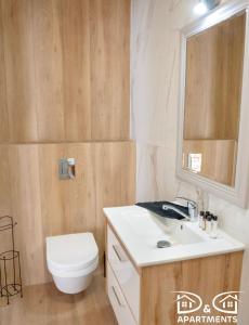 a bathroom with a toilet and a sink and a mirror at Pine Tree House 9 D&D Apartments in Międzywodzie