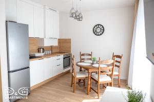 a kitchen with a table and chairs and a refrigerator at Pine Tree House 9 D&D Apartments in Międzywodzie