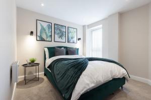 a bedroom with a bed with a green comforter at Stylish Central Leeds Arena Apartment Free Parking in Leeds +19 photos