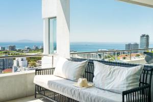 a balcony with a bench with a view of the ocean at Ocean Vue in Cape Town
