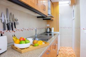 a kitchen counter with a bowl of fruit on a cutting board at Stay In Calm Beach in Santa Pola +33 photos