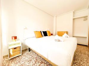 a white bedroom with two beds and a night stand at Stay In Calm Beach in Santa Pola