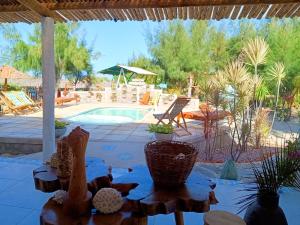 a patio with a pool and chairs and a table at Flats Macapá Meu Amor 10 in Luis Correia